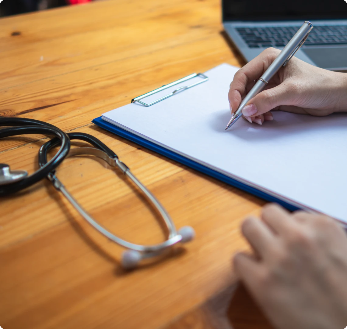Healthcare worker writing on clipboard